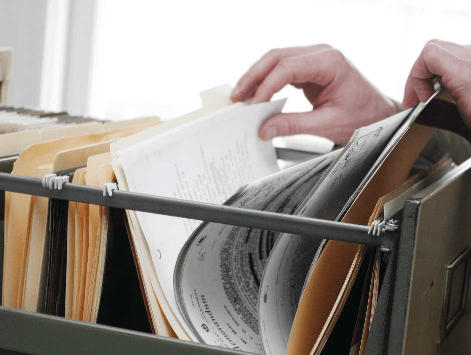 Person flicking through a filing cabinet
