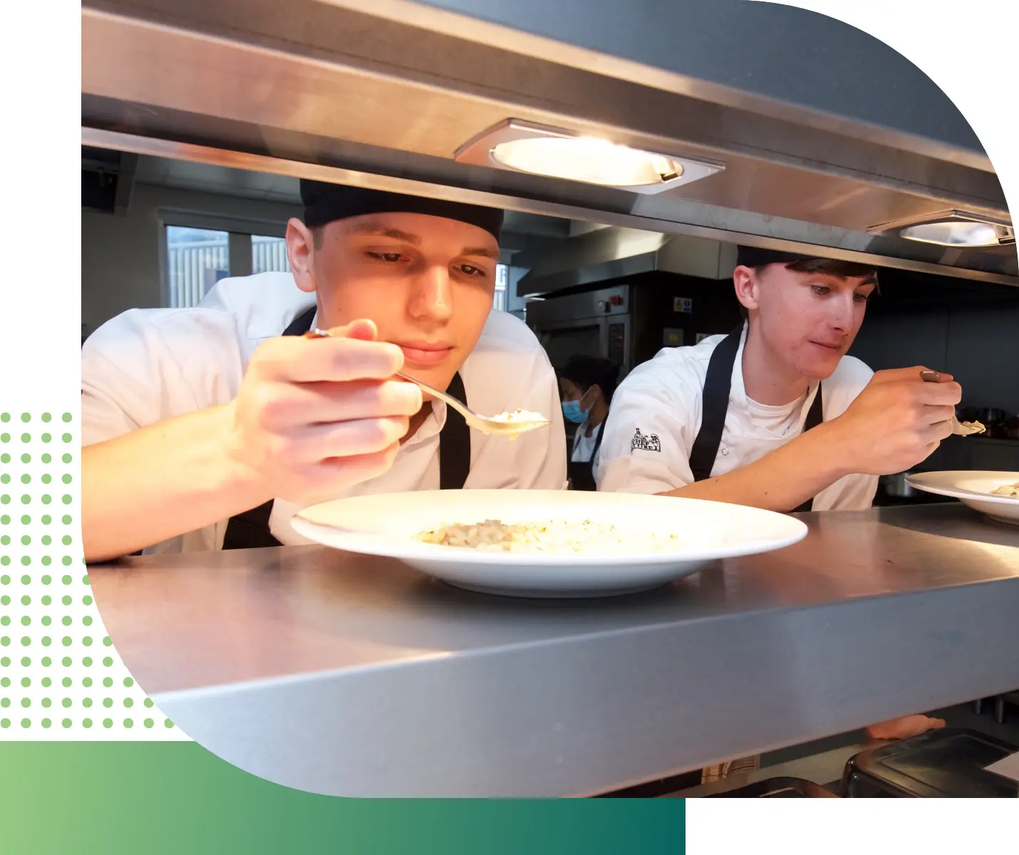 Two trainee chefs tasting a meal