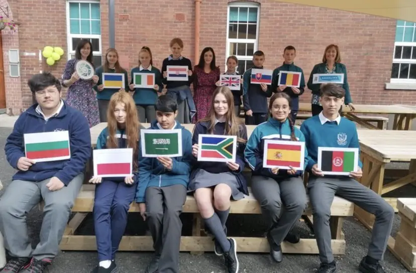 students from Curragh Community College holding flags from different countries to represent ethos in the school 