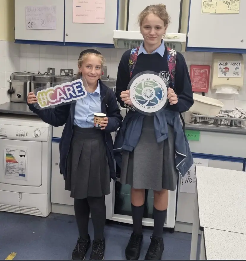 Curragh Community School students holding a #care sign and a KWETB sign representing the ethos and core values of the school 
