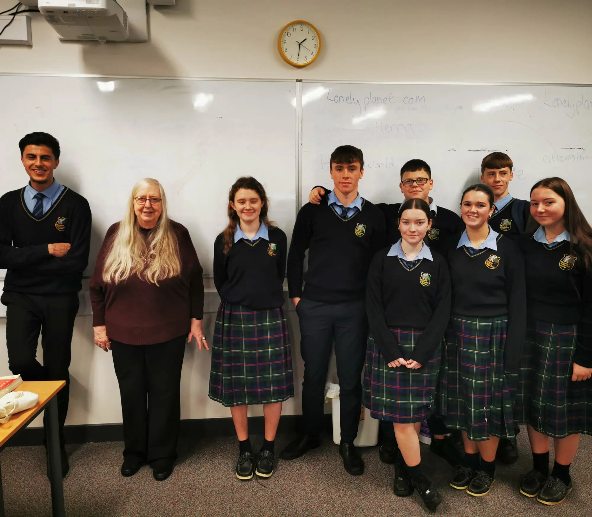 Maynooth Community College students standing with Leaving Cert Poet, Eiléan Ní Chuilleanáin in a classroom 