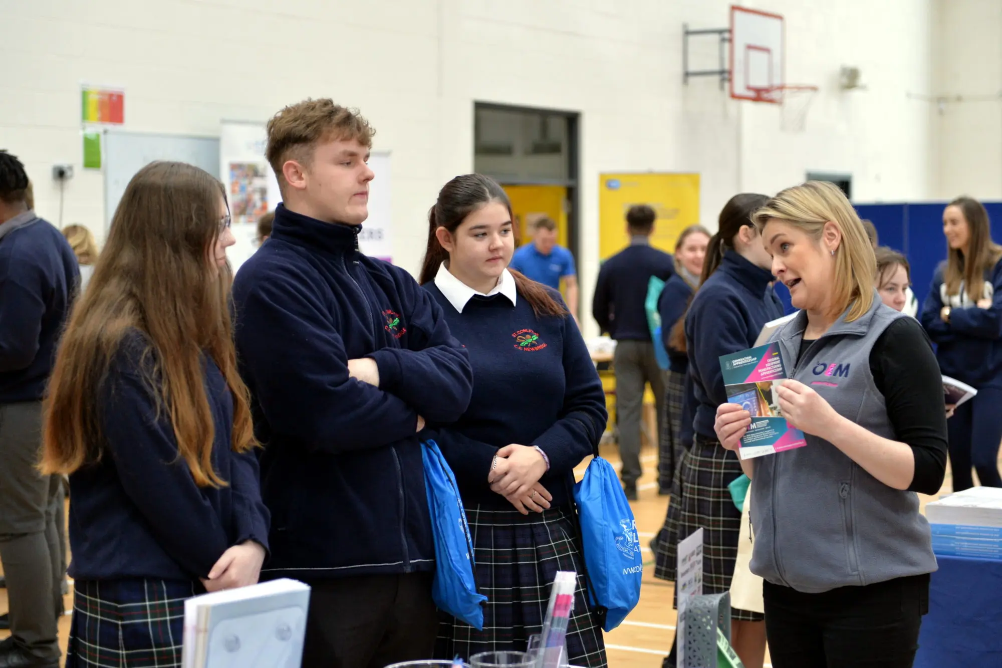 Students listening to a lady at a stand at the St. Conleth's Community college careers fair 