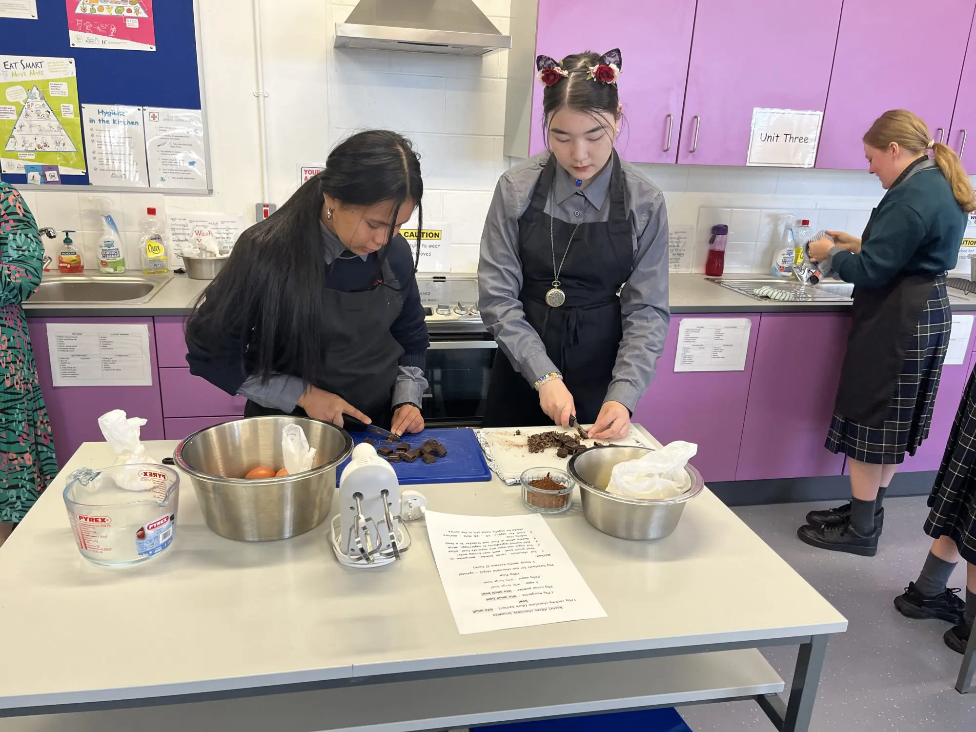 sixth class students at St. Conleth's Community College in the home economics classroom watching students cut up chocolate for brownies