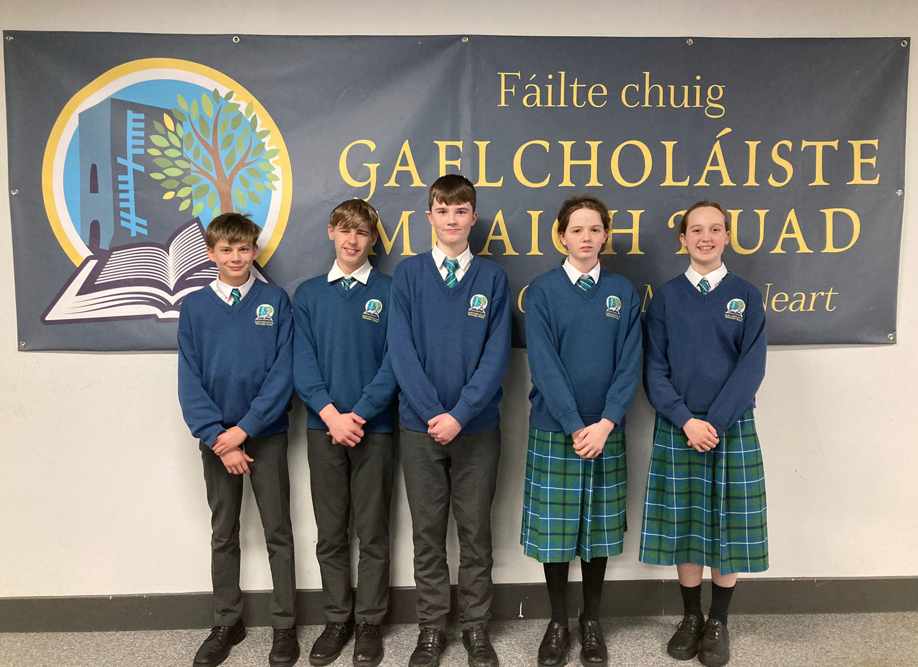 Gaelcholáiste Mhaigh Nuad students who entered into the BT Young Scientist Exhibition standing in front of their school poster  