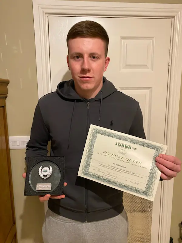 Student from Confey College standing with his award and certificate for getting 100% in his Leaving Cert Applied Exam. 