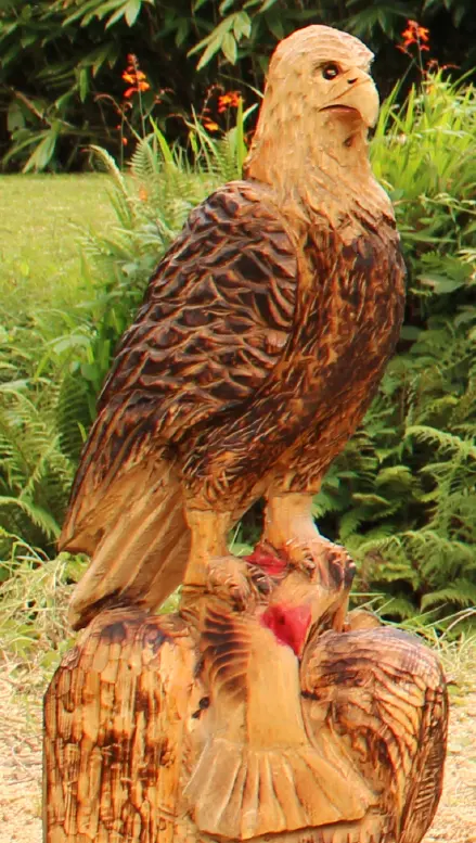 Wooden eagle carving on a tree stump in a garden