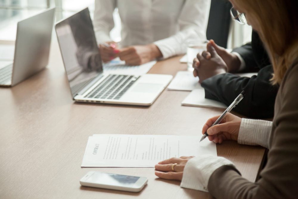 Laptop & Person signing a document