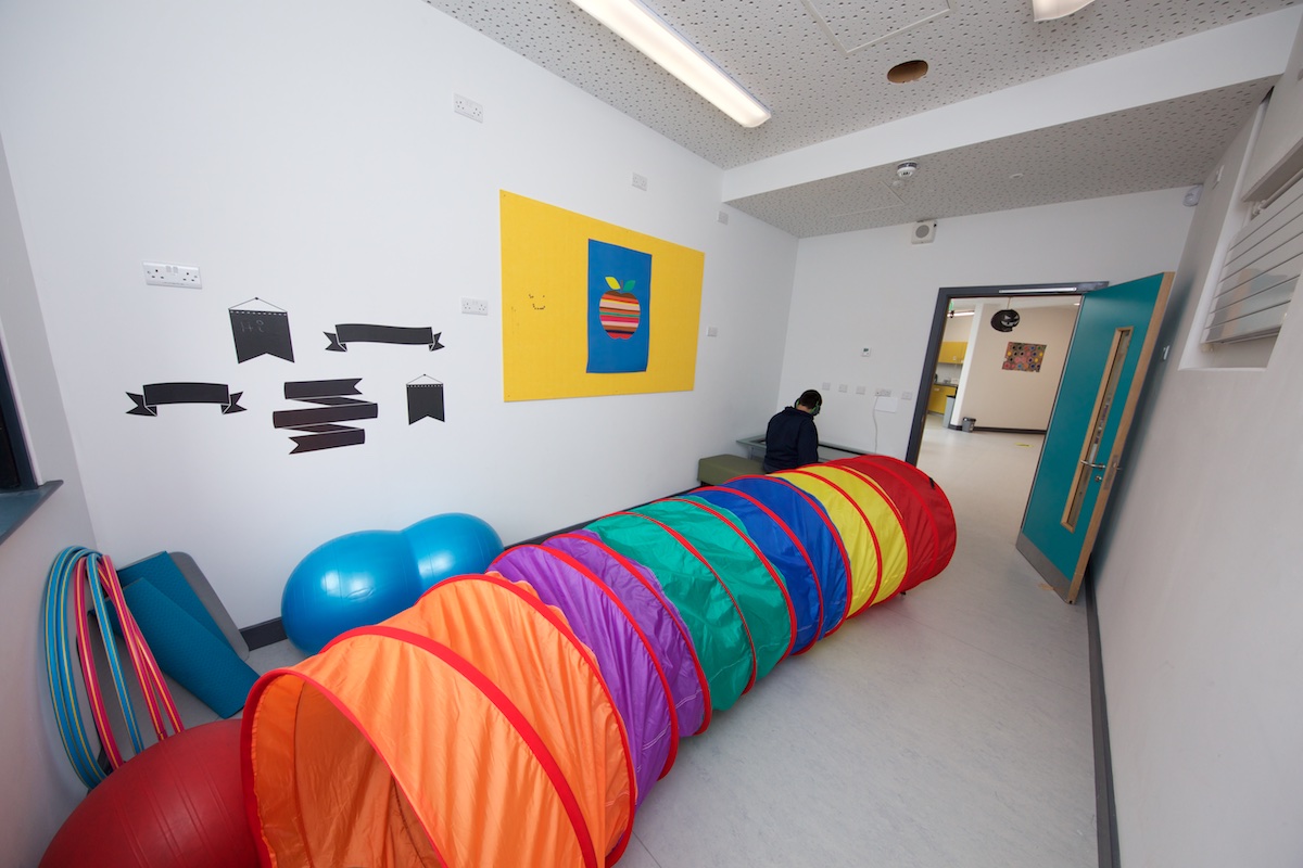 Student in a quiet room with a crawl tunnel and balance ball equipment